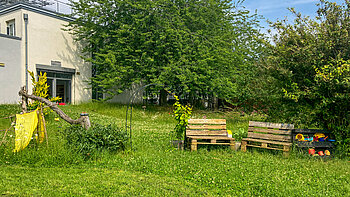 Grüner Garten mit Sitzgelegenheiten der Kita Kleine Riesen Magdeburg